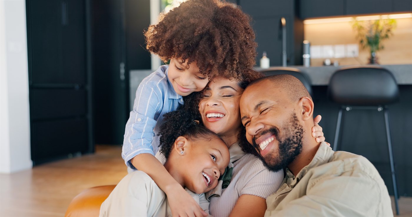 Família feliz se abraçando em casa